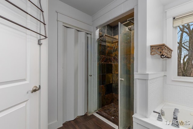 full bath with a bath, a shower stall, and wood finished floors