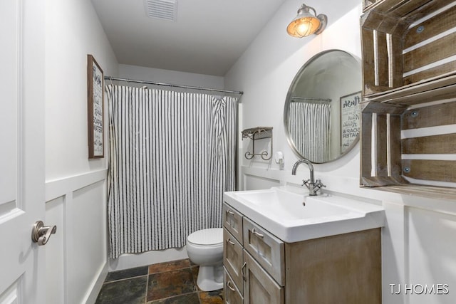 bathroom with visible vents, curtained shower, toilet, vanity, and stone finish flooring