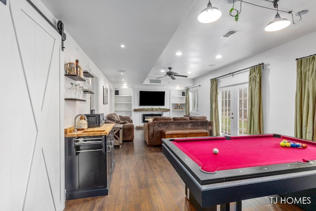 recreation room featuring ceiling fan, dark wood-style floors, visible vents, french doors, and built in shelves