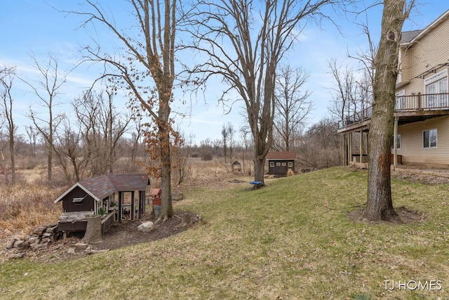 view of yard with a deck and an outdoor structure