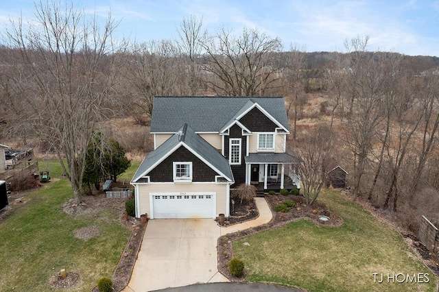 traditional home featuring a garage, covered porch, roof with shingles, a front yard, and driveway