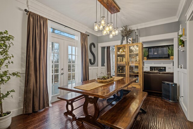 dining room featuring dark wood-type flooring, crown molding, french doors, and an inviting chandelier