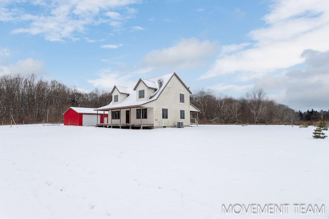 11559 Williams Rd, Montague, MI 49437 - view of snowy exterior with a garage, an outbuilding, and cooling unit