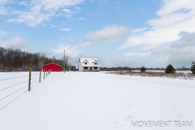 11559 Williams Rd, Montague, MI 49437 - yard covered in snow featuring an outdoor structure, fence, and an outbuilding