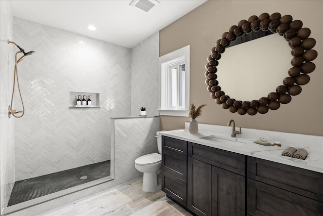 4070 Metamora Rdg, Metamora, MI 48455 - full bathroom featuring a tile shower, vanity, visible vents, toilet, and wood finished floors