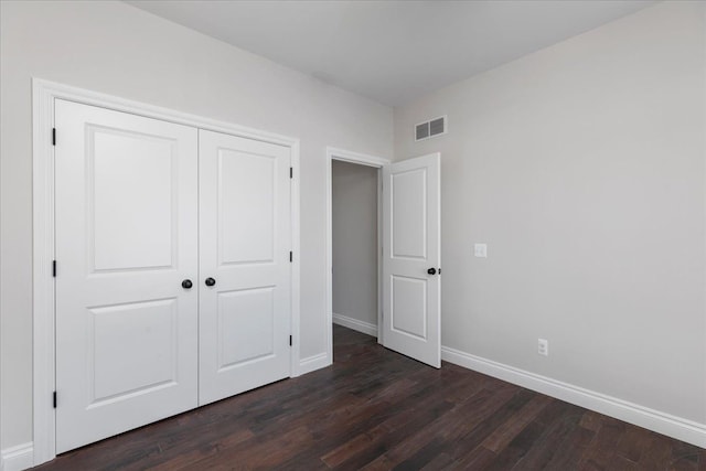 4070 Metamora Rdg, Metamora, MI 48455 - unfurnished bedroom with a closet, dark wood-type flooring, visible vents, and baseboards