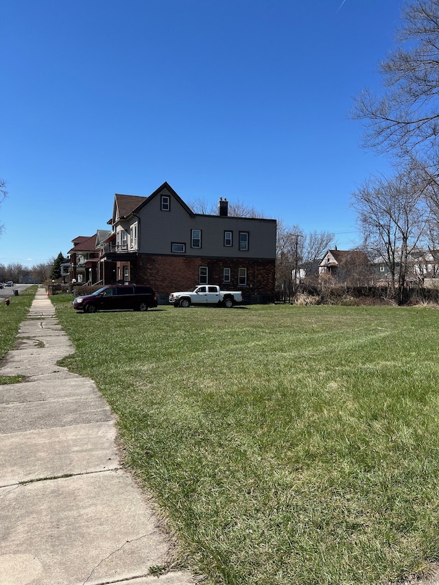 190 W Buena Vista St, Highland Park, MI 48203 - exterior space featuring a yard, brick siding, and a chimney