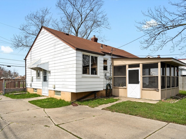 29060 Michigan St, Roseville, MI 48066 - rear view of property featuring a yard, fence, a sunroom, and a chimney