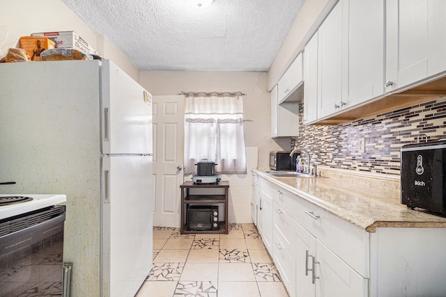 kitchen featuring a sink, a textured ceiling, light countertops, tasteful backsplash, and white cabinetry