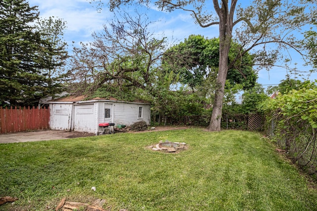 view of yard featuring an outdoor structure and a fire pit