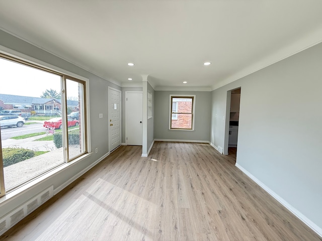unfurnished living room featuring recessed lighting, visible vents, light wood-style flooring, baseboards, and ornamental molding