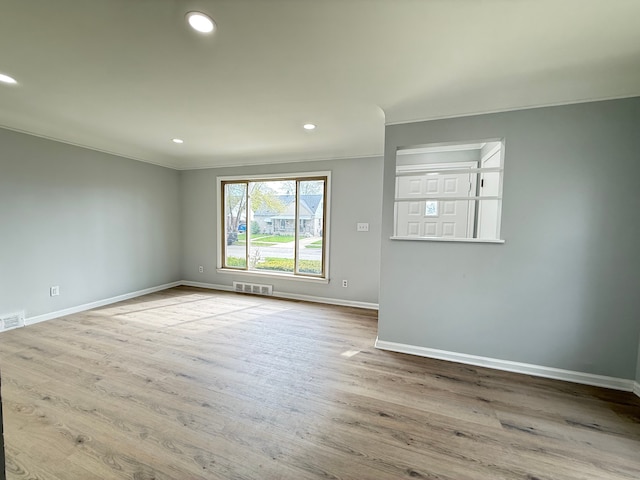 unfurnished room with ornamental molding, recessed lighting, wood finished floors, and baseboards