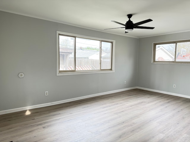 unfurnished room featuring crown molding, ceiling fan, wood finished floors, and baseboards