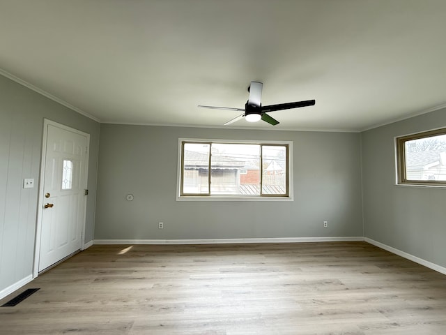 spare room featuring wood finished floors, ceiling fan, and ornamental molding
