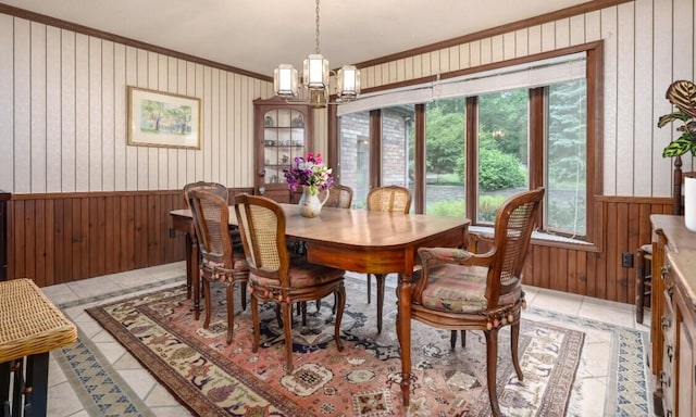 9420 Whim Trl, Richland, MI 49083 - dining area with an inviting chandelier, light tile patterned floors, wood walls, a wainscoted wall, and crown molding