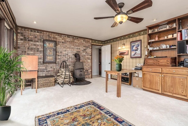 9420 Whim Trl, Richland, MI 49083 - office area featuring crown molding, a wood stove, ceiling fan, brick wall, and light carpet