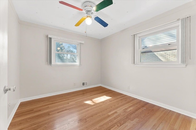 spare room with baseboards, a ceiling fan, visible vents, and light wood-style floors