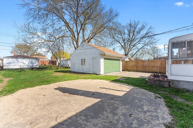 view of yard featuring fence, an outbuilding, and a detached garage