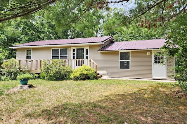 ranch-style house featuring metal roof and a front lawn