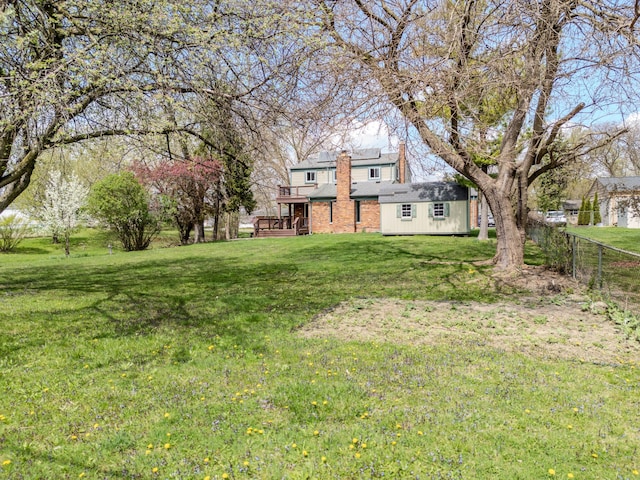 view of yard featuring fence, an outbuilding, and a deck