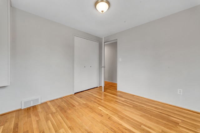spare room featuring visible vents, light wood-style flooring, and baseboards