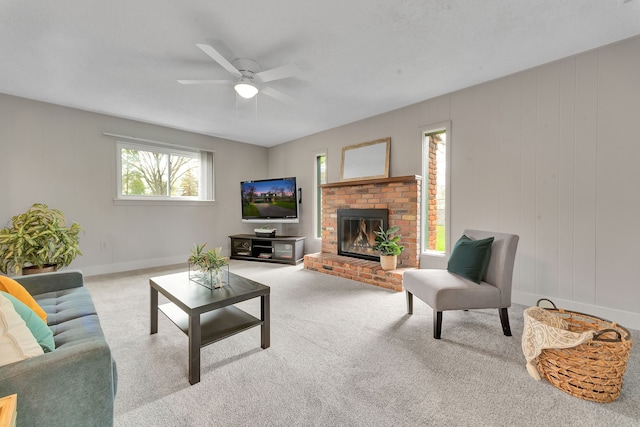 living area with baseboards, carpet, ceiling fan, and a fireplace