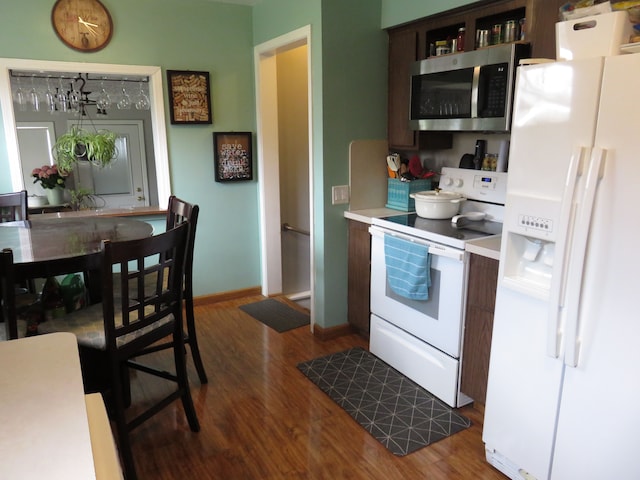 5900 Commerce Rd, West Bloomfield, MI 48324 - kitchen with dark wood-type flooring, light countertops, white appliances, and baseboards