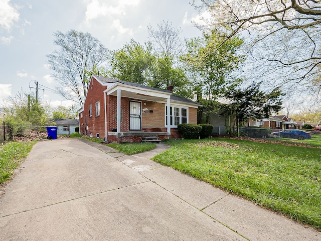bungalow-style house featuring brick siding, covered porch, and driveway