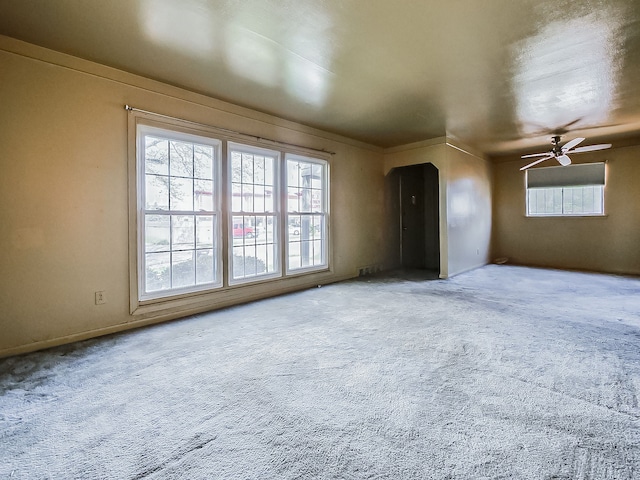 carpeted empty room featuring a ceiling fan