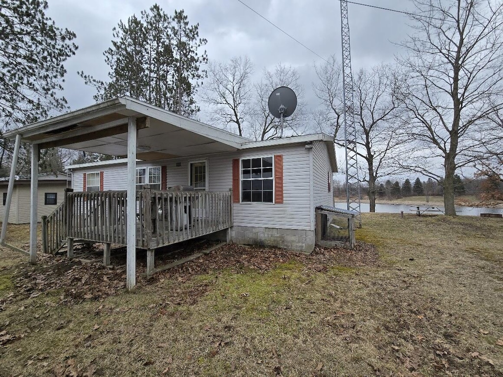 back of property featuring a deck with water view