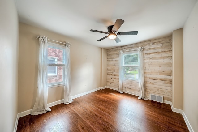 3015 N Wilson Ave, Royal Oak, MI 48073 - unfurnished room featuring wood finished floors, wood walls, visible vents, baseboards, and ceiling fan