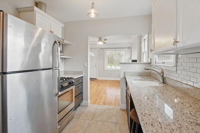 kitchen with tasteful backsplash, appliances with stainless steel finishes, white cabinetry, and a sink