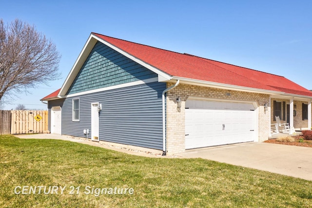 view of side of property with concrete driveway, a yard, brick siding, and fence