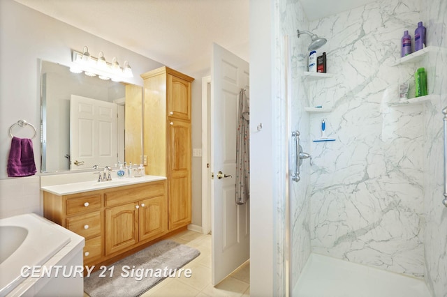 full bath with a marble finish shower, tile patterned floors, and vanity