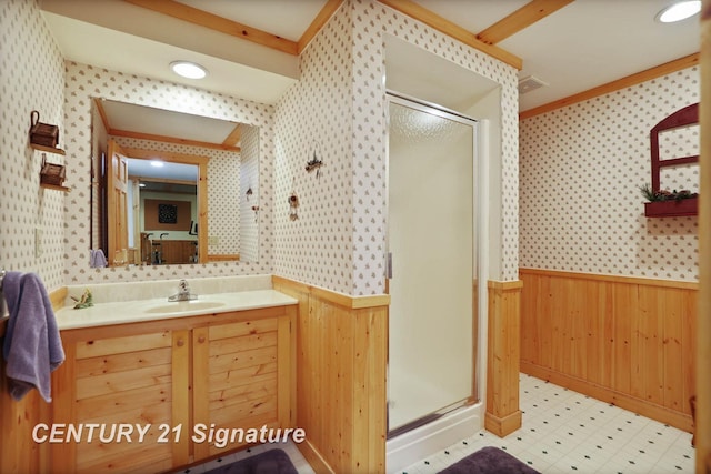 full bath with visible vents, a shower stall, vanity, wallpapered walls, and a wainscoted wall