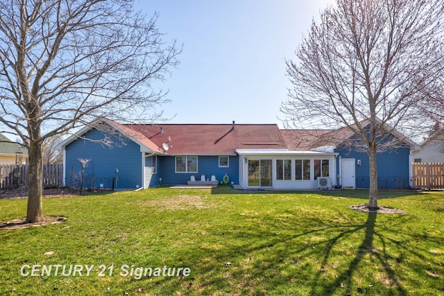 back of house with roof with shingles, a sunroom, fence, and a lawn
