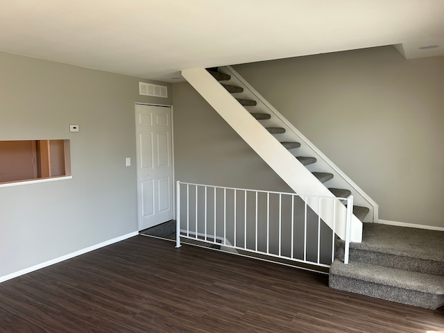 stairs with visible vents, baseboards, and wood finished floors