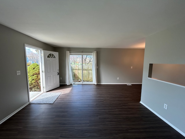 foyer with a healthy amount of sunlight, baseboards, and dark wood-style floors