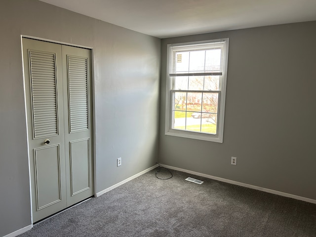 unfurnished bedroom featuring a closet, baseboards, visible vents, and carpet floors