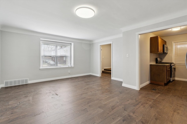 4677 Chatsworth St, Detroit, MI 48224 - unfurnished living room with stairway, baseboards, dark wood-style flooring, and visible vents