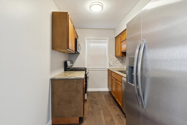 4677 Chatsworth St, Detroit, MI 48224 - kitchen with appliances with stainless steel finishes, light countertops, brown cabinetry, tasteful backsplash, and dark wood-style floors