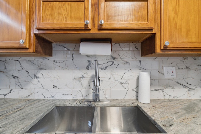 4677 Chatsworth St, Detroit, MI 48224 - kitchen featuring a sink, light stone counters, backsplash, and brown cabinets