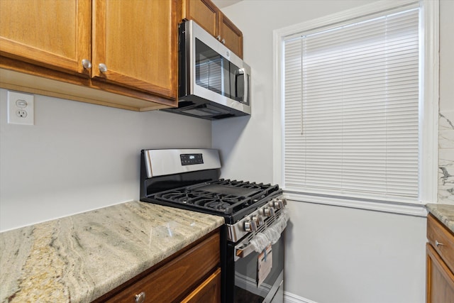 4677 Chatsworth St, Detroit, MI 48224 - kitchen featuring brown cabinets, stainless steel appliances, and light stone counters