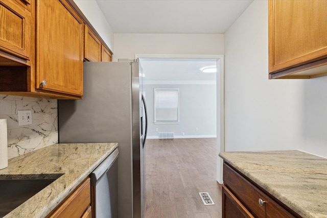 4677 Chatsworth St, Detroit, MI 48224 - kitchen with backsplash, visible vents, light stone countertops, dishwasher, and light wood finished floors