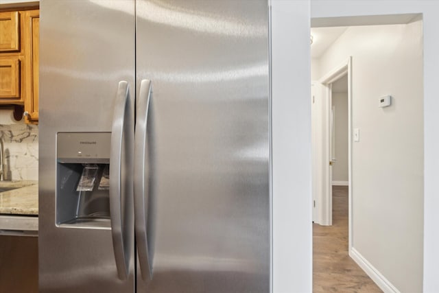 4677 Chatsworth St, Detroit, MI 48224 - interior details with brown cabinetry, baseboards, a sink, light wood-style flooring, and appliances with stainless steel finishes