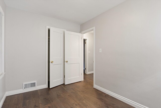 4677 Chatsworth St, Detroit, MI 48224 - unfurnished bedroom featuring dark wood-style flooring, baseboards, and visible vents