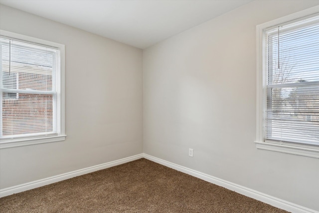 4677 Chatsworth St, Detroit, MI 48224 - empty room featuring baseboards, dark carpet, and a wealth of natural light
