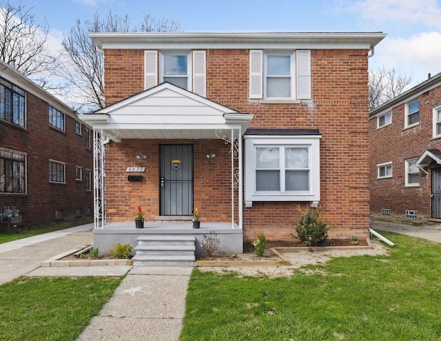traditional-style house with a front lawn and brick siding