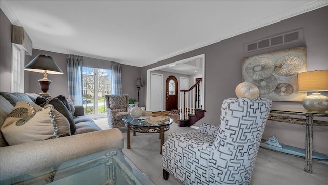 living room with carpet floors, visible vents, crown molding, and stairs