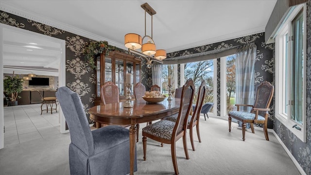 dining space with wallpapered walls, ornamental molding, and a healthy amount of sunlight